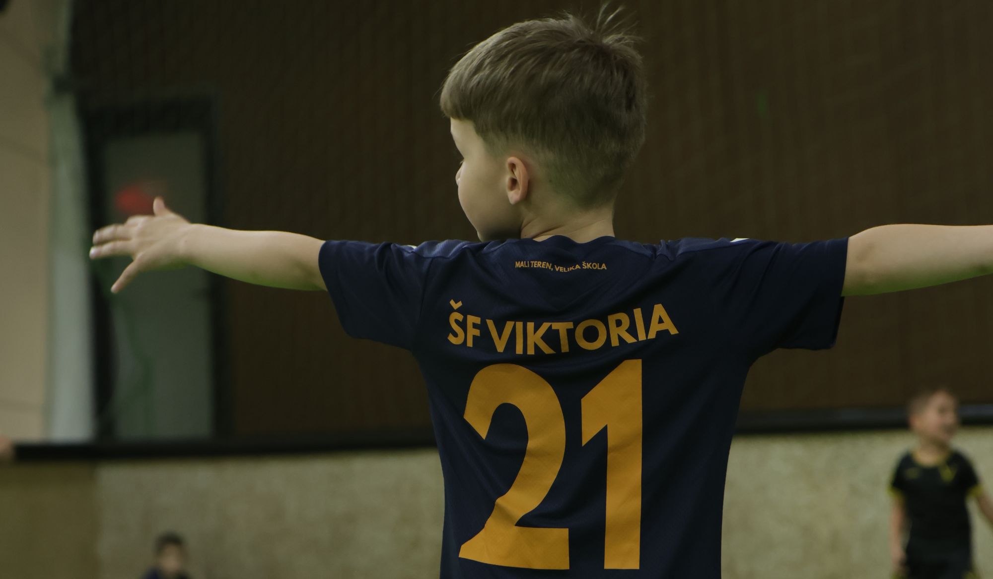 Dete sa brojem 21 širi ruke na treningu škole fudbala Viktoria